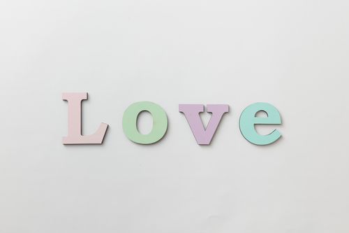Free Pastel letters spelling 'Love' on a white background create a minimal and elegant design. Stock Photo