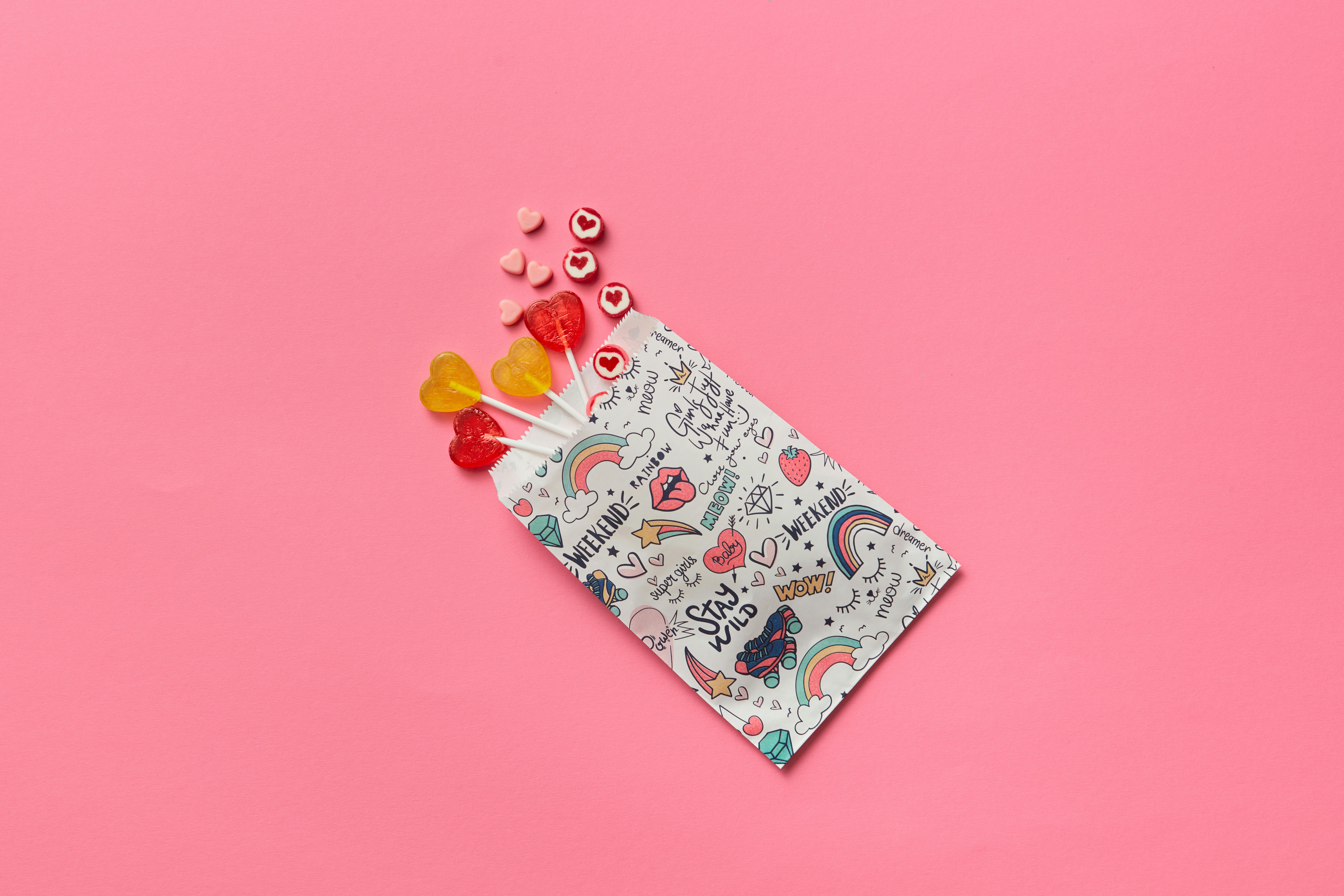 Heart Shaped Candies and Lollipops on Pink Background · Free Stock Photo