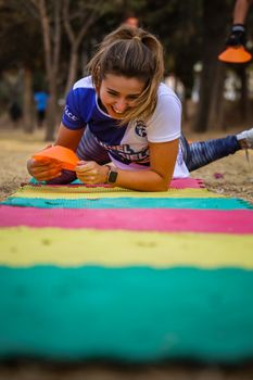 Smiling woman working out on colorful mat outdoors in Puebla, Mexico.