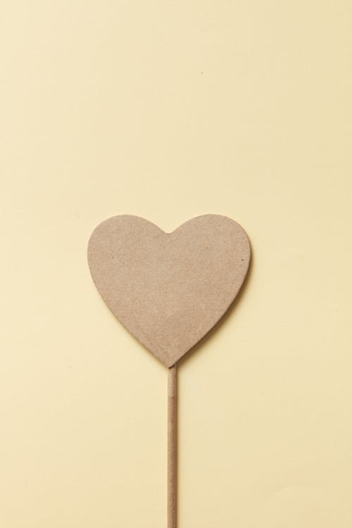 Heart Shaped Cardboard in Yellow Background 