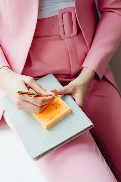 Free Person in Pink Pants Writing a Note Stock Photo