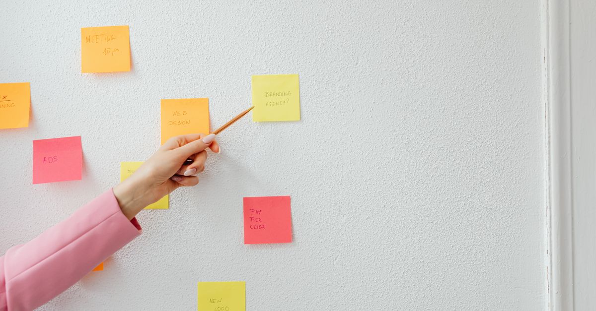 a whiteboard with sticky notes showing different decision-making frameworks like RACI, DACI, and consent-based decision making