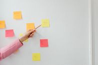 Person Holding Pink Sticky Note
