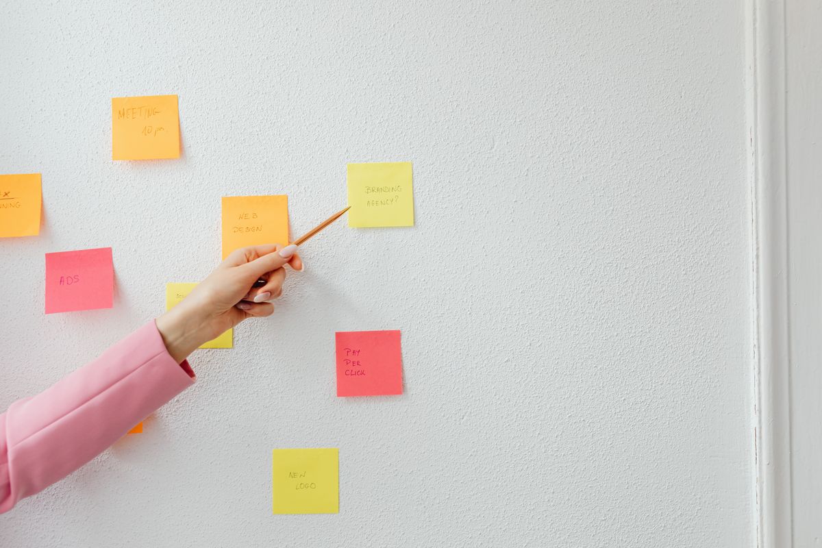 Formateur qui structure la scénarisation pédagogique d'un module avec des post-it au mur