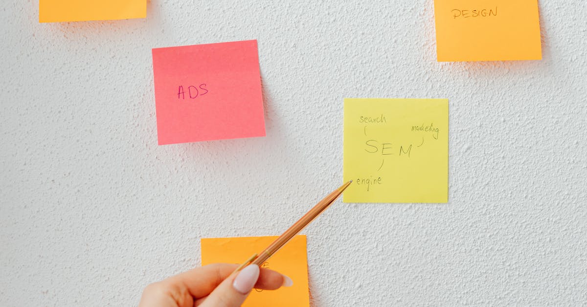 Person Holding a Pen Pointing on Sticky Notes · Free Stock Photo
