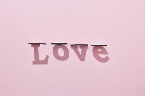 Free Creative love shadow art on a soft pastel pink background, symbolizing romance and affection. Stock Photo