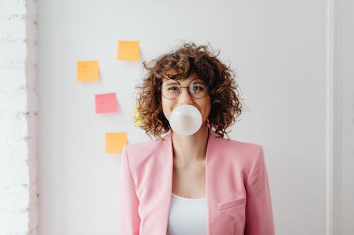 Woman in Pink Blazer Chewing a Bubble Gum