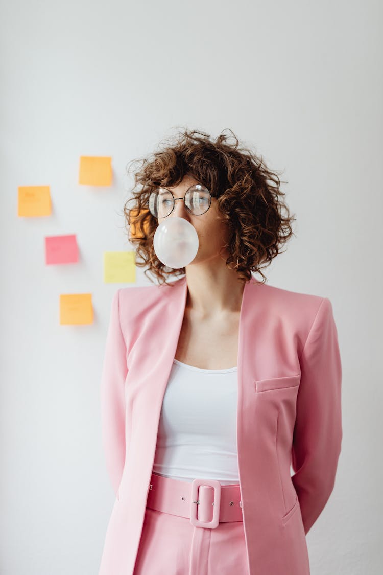 Woman In Pink Blazer Blowing Bubble Gum