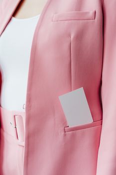 Close-up of a pink blazer with a business card in the pocket, ideal for business themes.
