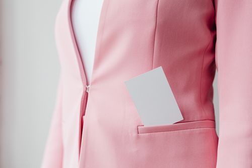 Free Close-up of a pink blazer featuring a business card in the pocket, stylish and professional. Stock Photo