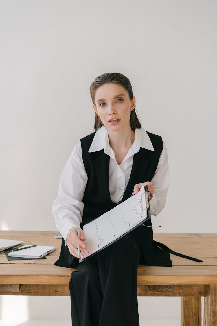 Woman Wearing A Suit Holding A Document