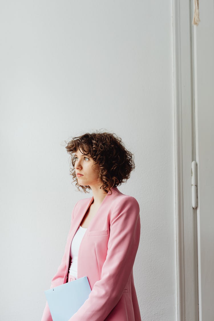 Woman In Pink Blazer Holding A Folder