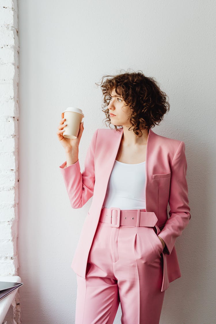 Woman In Pink Suit Holding Takeaway Coffee