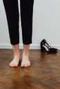 Person in Black Pants Standing on Brown Wooden Floor