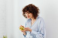 Woman in White Dress Shirt Holding Yellow Flower