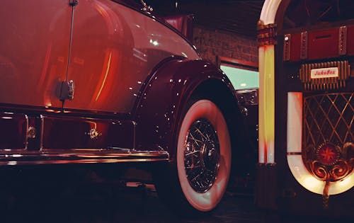 Lighted Jukebox Beside White and Brown Car