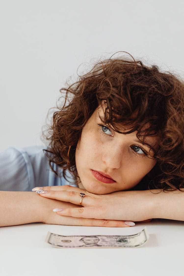 Woman With Curly Hair Resting Her Head On The Table