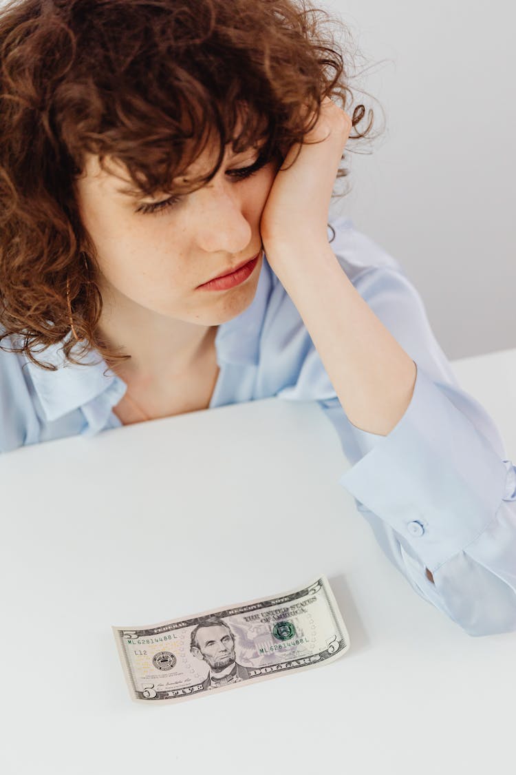 A Woman Looking At The Paper Money O N The Table