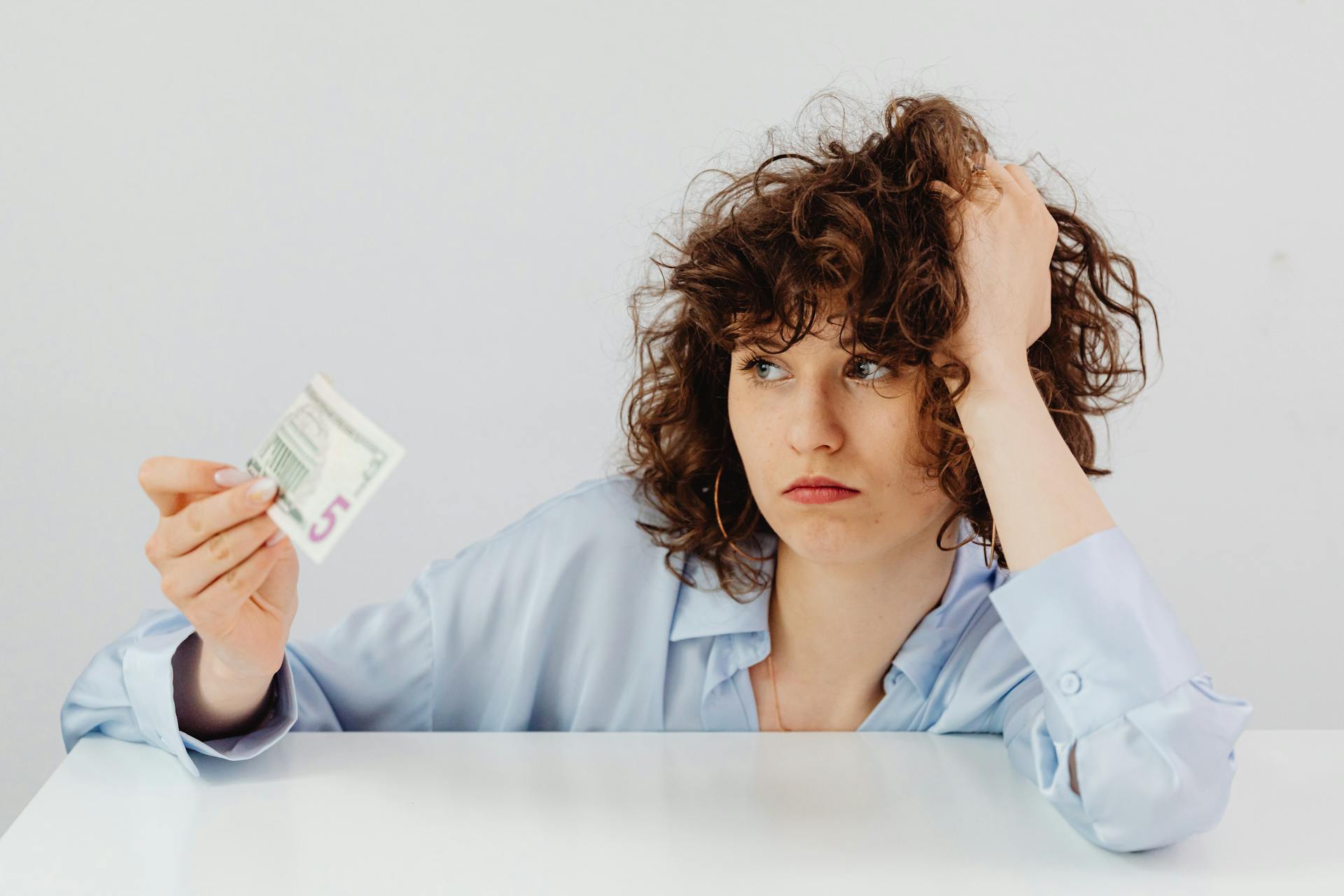 Curly-Haired Woman Holding a Paper Money