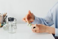 A Person Using Rubber Band to Tie Up the Paper Money