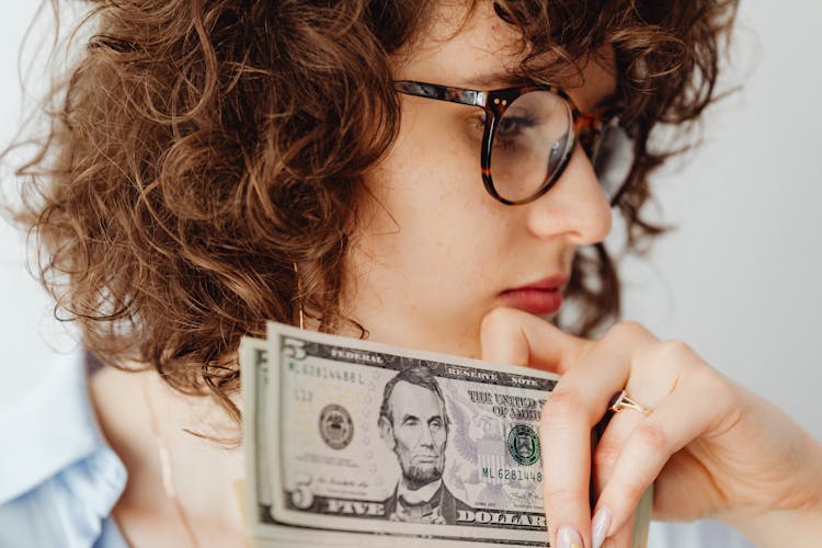 A Woman Wearing Eyeglasses Holding Money