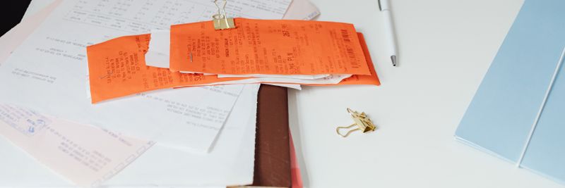 Close-up of a tidy desk with receipts, documents, and office stationery for business organization.