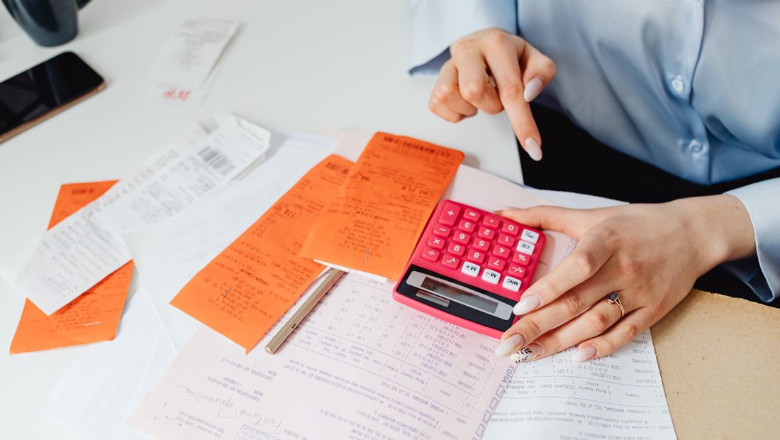 Personne calculant des reçus avec une calculatrice