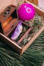 From above of decorative wooden box with green spruce needles and purple sparkling ball