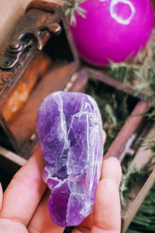 Person showing natural Amethyst against stylish box