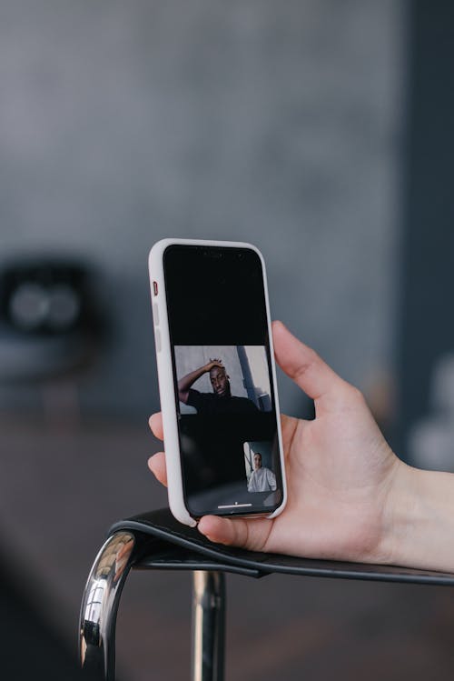 A Person Holding a Cellphone while Having a Video Call