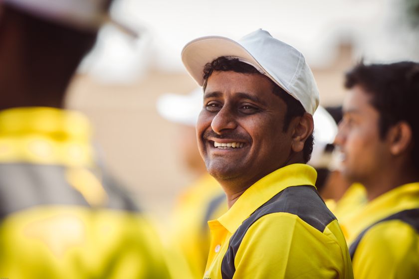 Smiling worker in a yellow uniform and cap