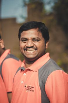 Portrait of a joyful man smiling brightly outdoors in a polo shirt.