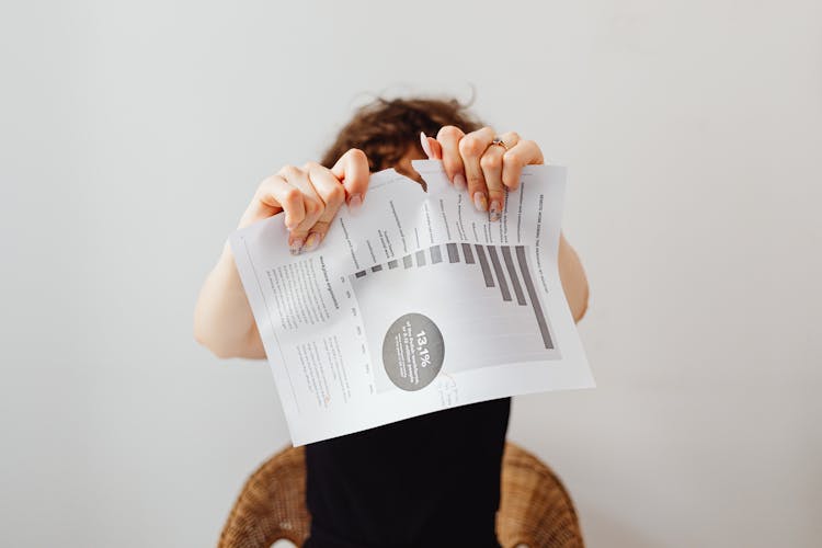 A Person Tearing Apart A Piece Of Paper