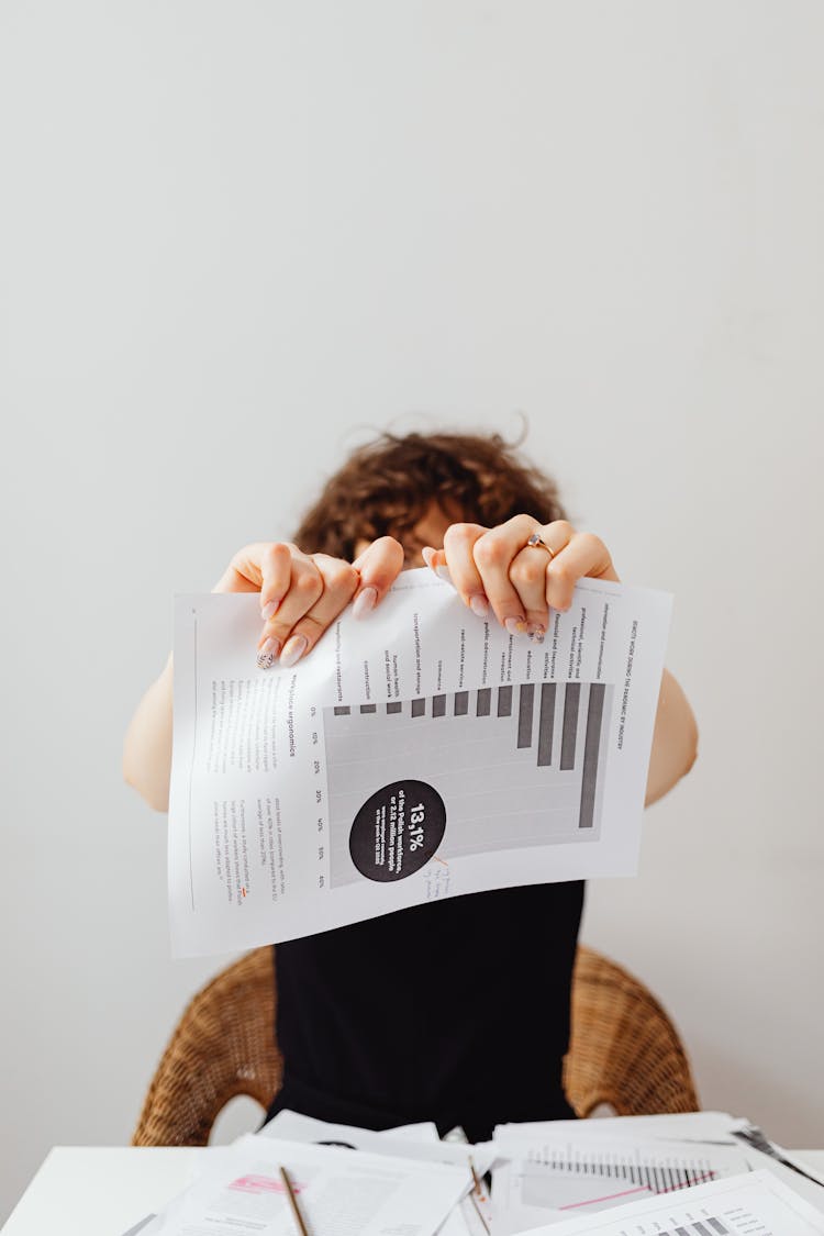 A Person Tearing Apart A Piece Of Paper