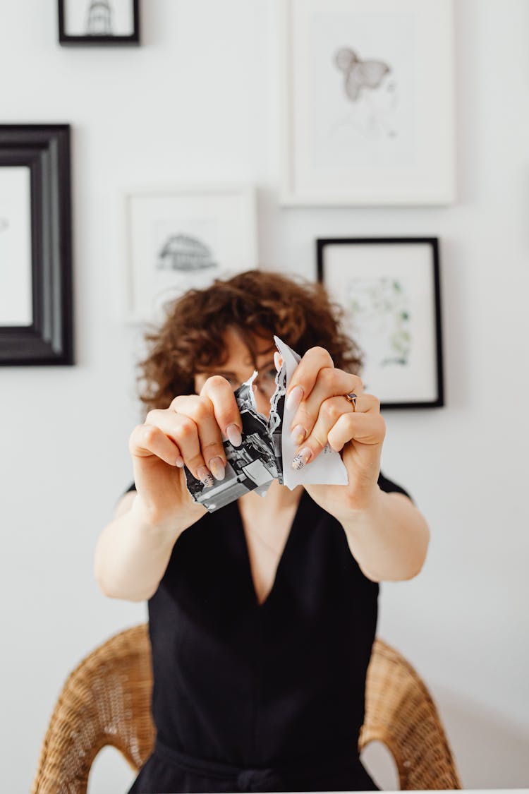 A Person Tearing A Piece Of Paper Into Pieces