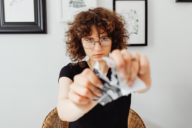 Woman In Black Shirt Tearing A Paper