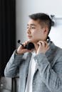 Man in Gray Suit Jacket Holding His Headphones
