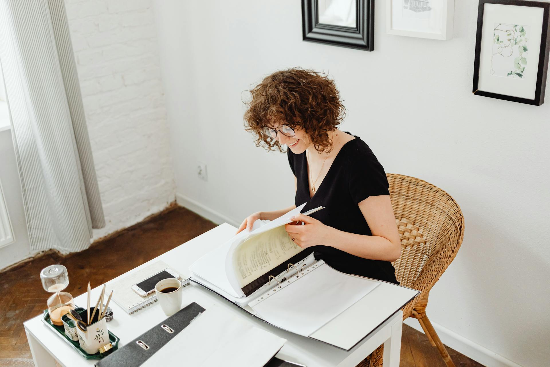 A caucasian woman reviews documents in a comfortable home office.