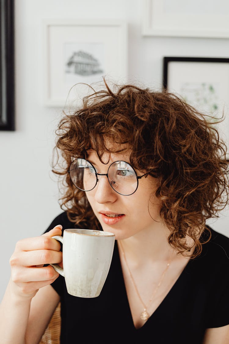 Short-Haired Woman In Black V-Neck Shirt Drinking Coffee