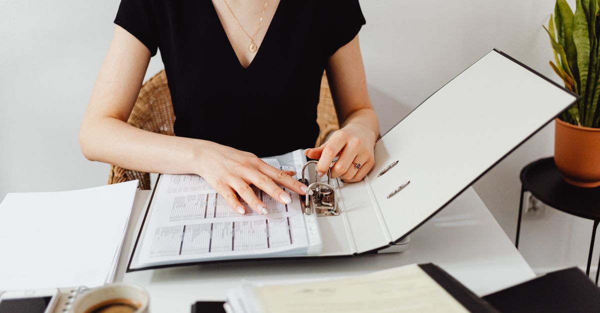 person organizing important financial documents in folders at home