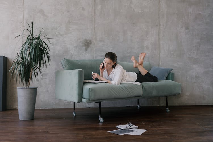 Woman In Lying On Couch Talking On Phone