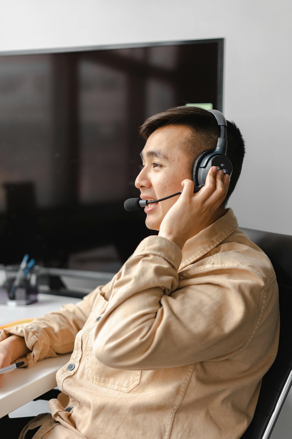 Operatore di call center con cuffia in moderno open space d'ufficio