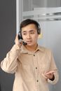 Man in Brown Button Up Shirt Wearing Black Headphones