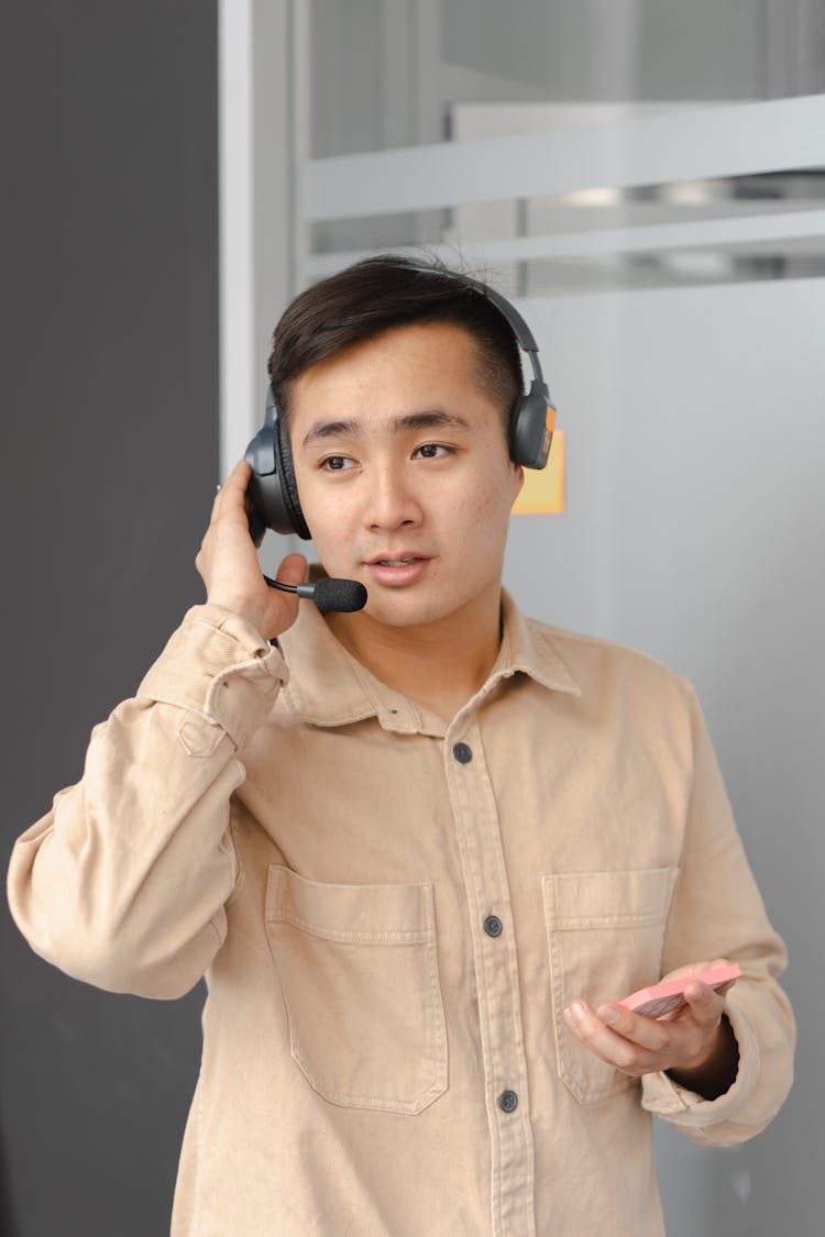 Man In Beige Button Up Shirt Wearing His Headphone