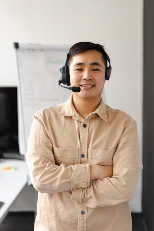 Photo of a Man with a Headset Posing with His Arms Crossed