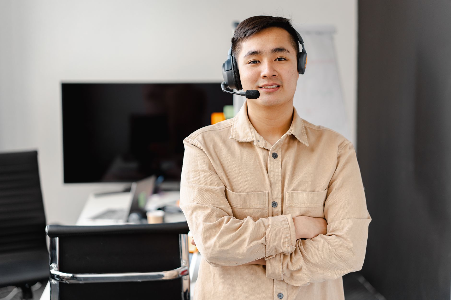 Smiling call center agent with headset in modern office, exuding professionalism and friendliness.