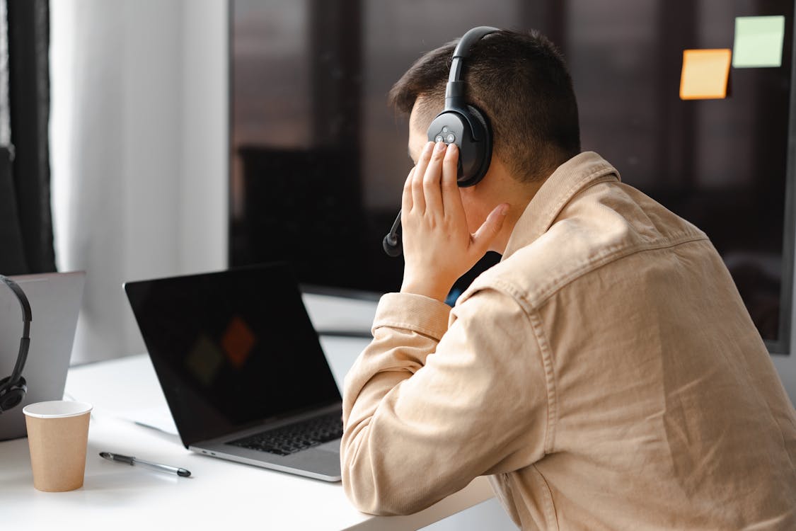 Free Man Wearing His Headphone in Front of His Laptop Stock Photo