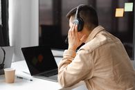 Man in Brown Jacket Using Black Headphones