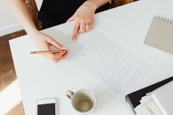 High-Angle Shot of a Person Writing on the Paper Using a Pen