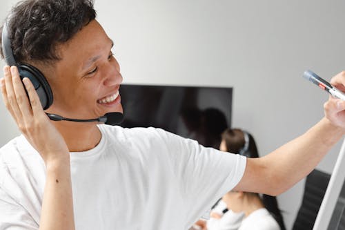 Man in White T-shirt Holding His Headphone